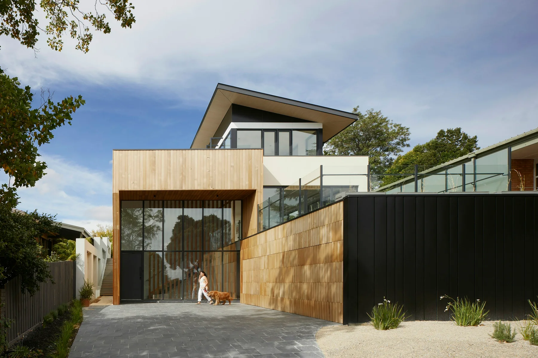 Contemporary house with timber cladding arranged around a sheltered courtyard